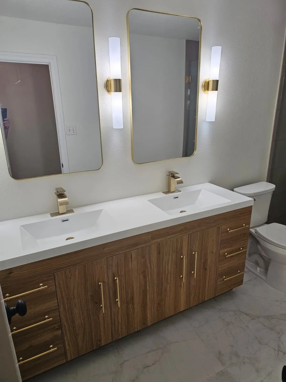 Bathroom remodel with a walnut double vanity and brushed gold fittings in Alden Bridge, The Woodlands, TX