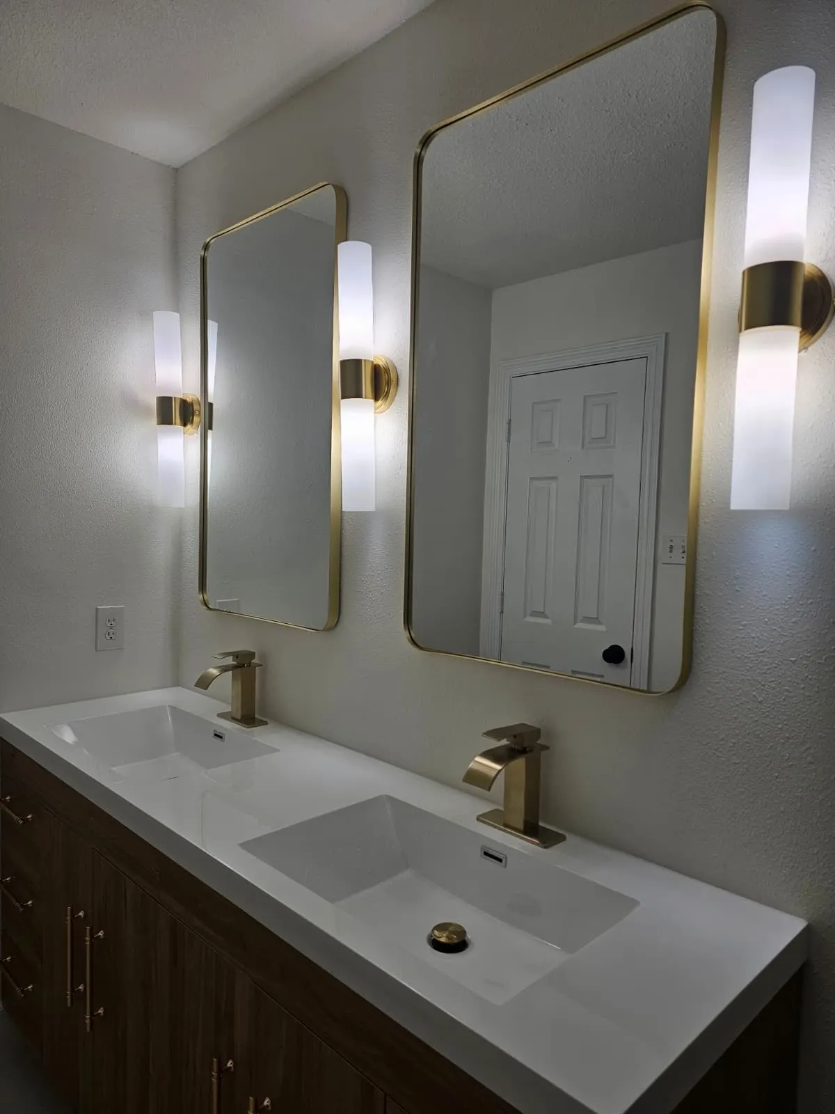 Bathroom remodel with a walnut double vanity and brushed gold fittings in Alden Bridge, The Woodlands, TX