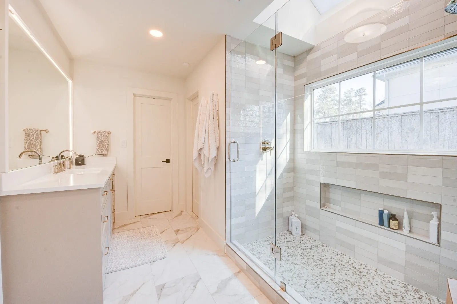 Marble bathroom with frameless glass and brushed nickel fittings in Carlton Woods, The Woodlands, TX