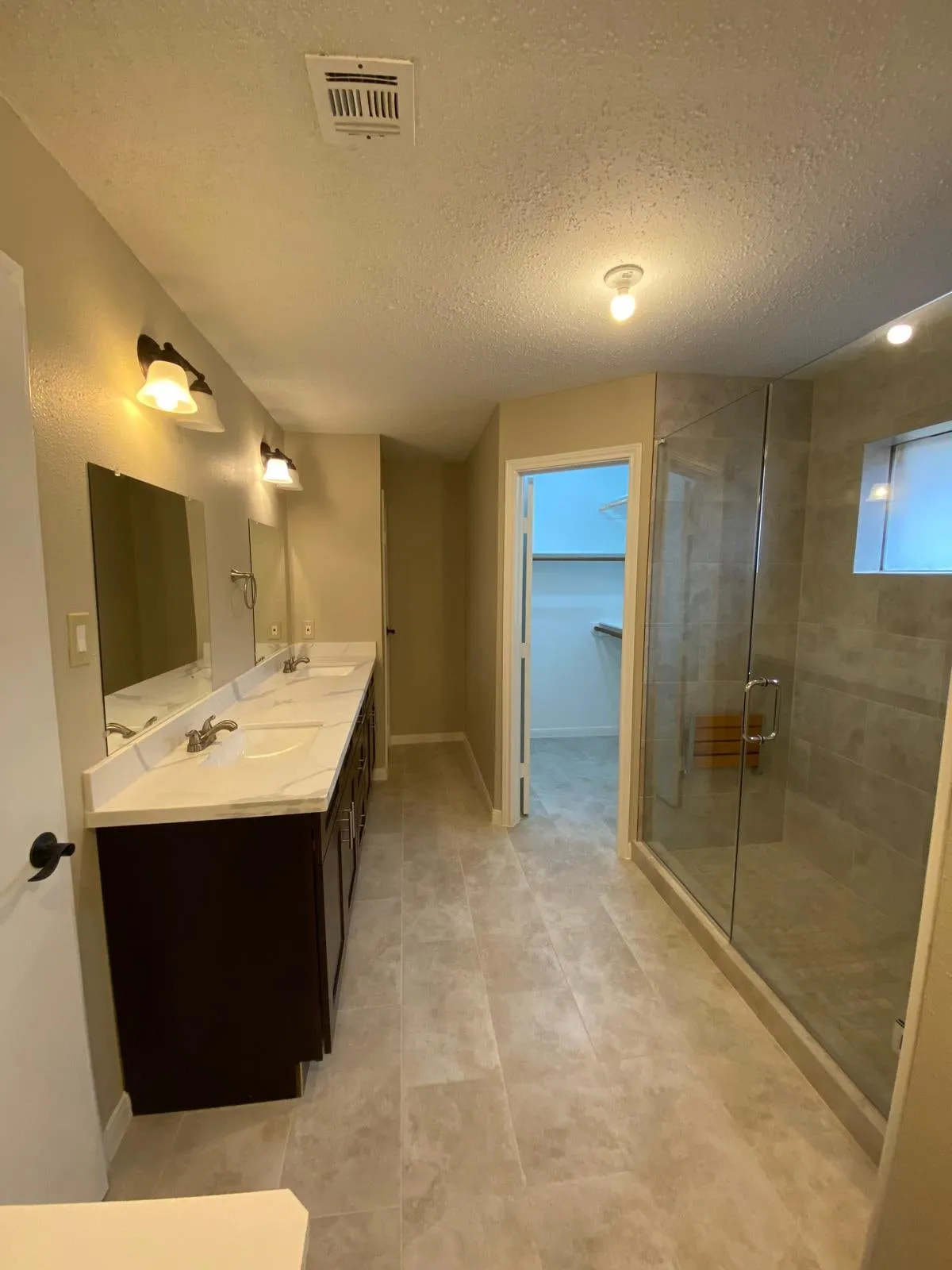 Bathroom remodel with a double vanity and a tiled walk-in shower in Cochran’s Crossing, The Woodlands, TX