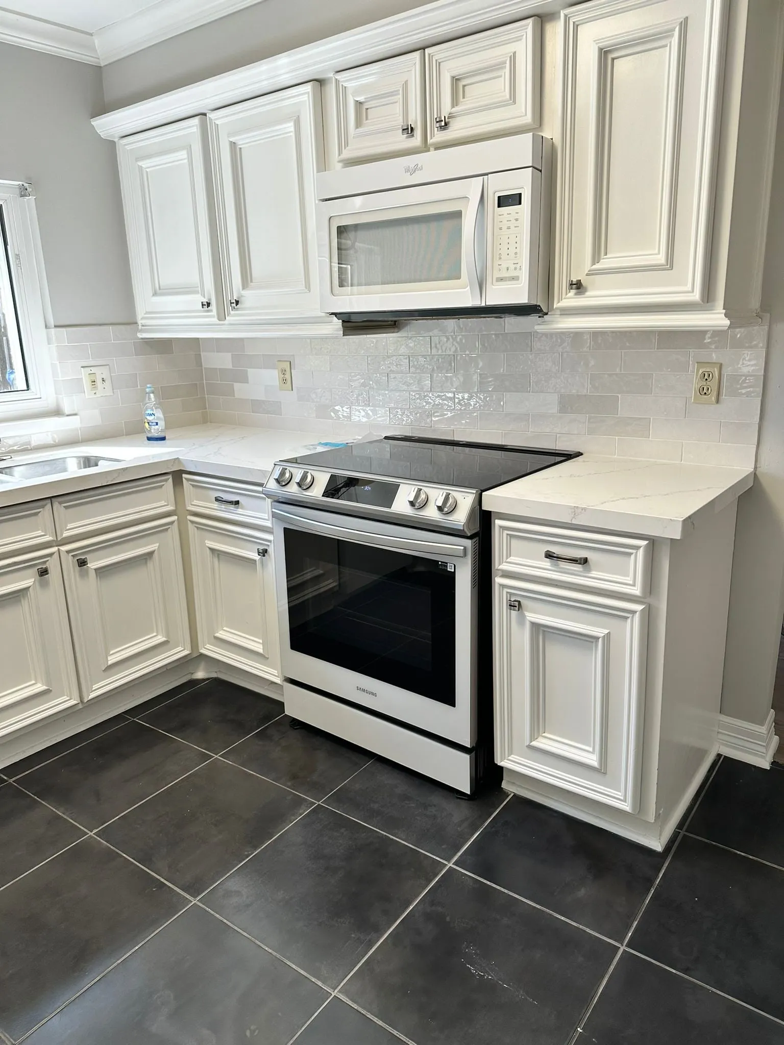Ivory raised-panel kitchen with quartz counters and a stone backsplash in Cochran’s Crossing, The Woodlands, TX