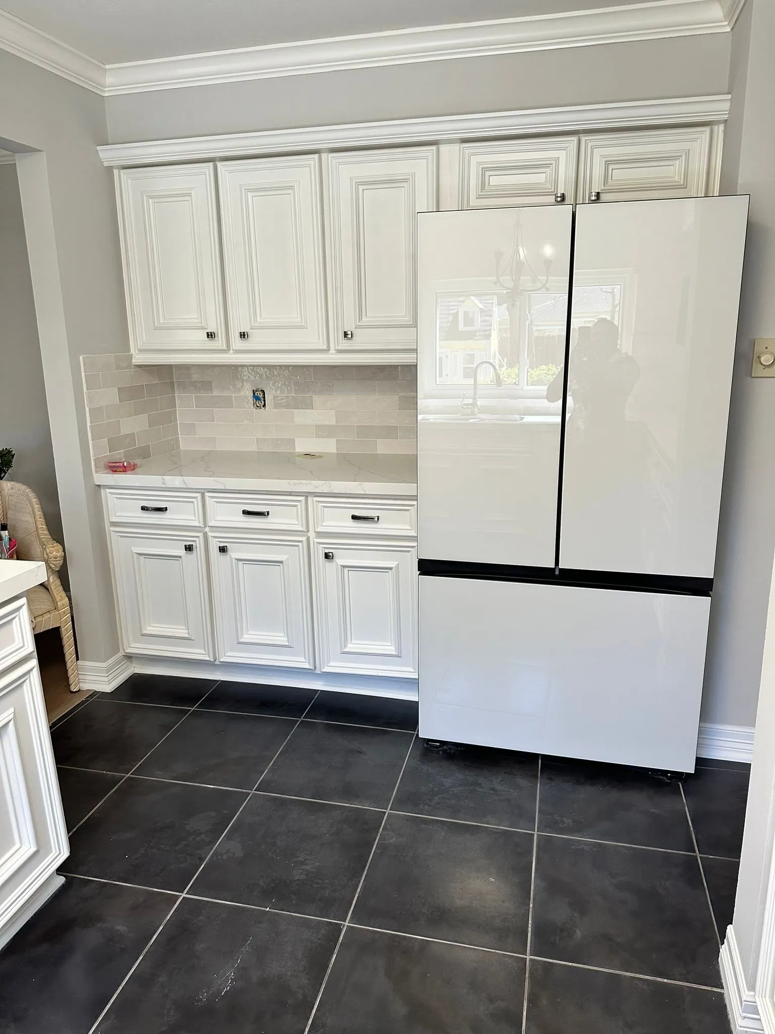 Ivory raised-panel kitchen with quartz counters and a stone backsplash in Cochran’s Crossing, The Woodlands, TX
