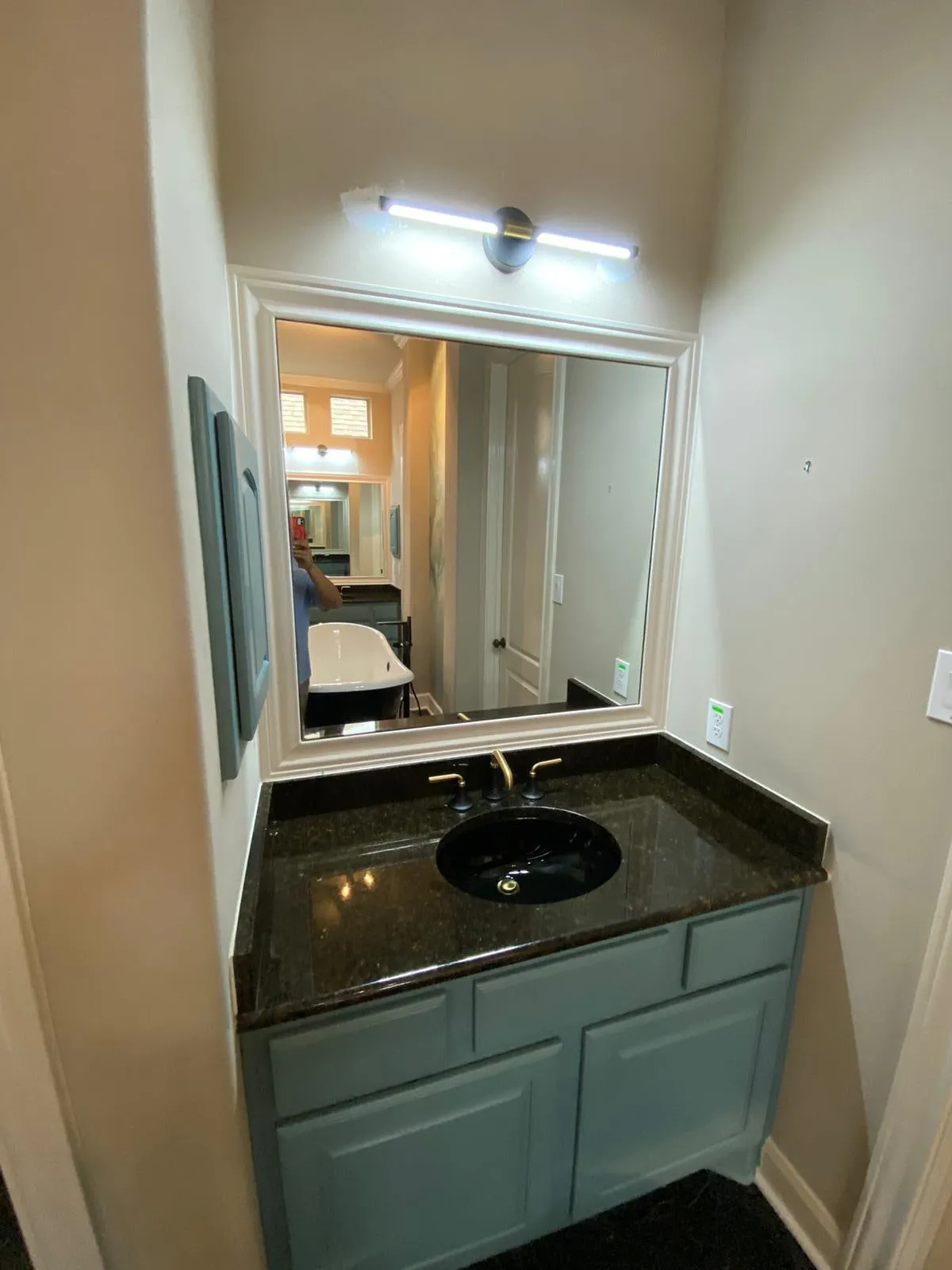 Bathroom remodel with a clawfoot tub, sage cabinetry, and gold penny-round shower tile in The Woodlands, TX