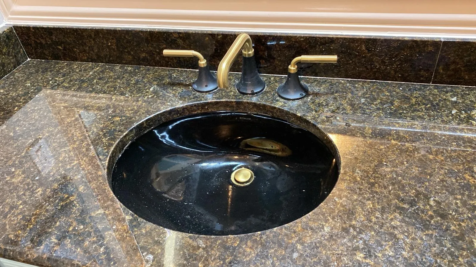 Bathroom remodel with a clawfoot tub, sage cabinetry, and gold penny-round shower tile in The Woodlands, TX