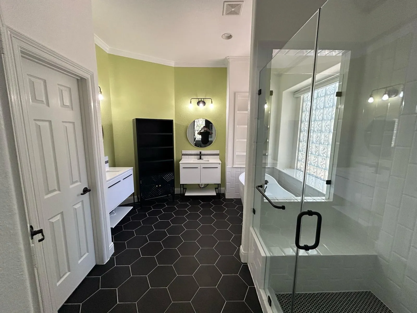 Bathroom remodel with a freestanding tub, black hexagon floor tile, and a floating vanity in The Woodlands, TX