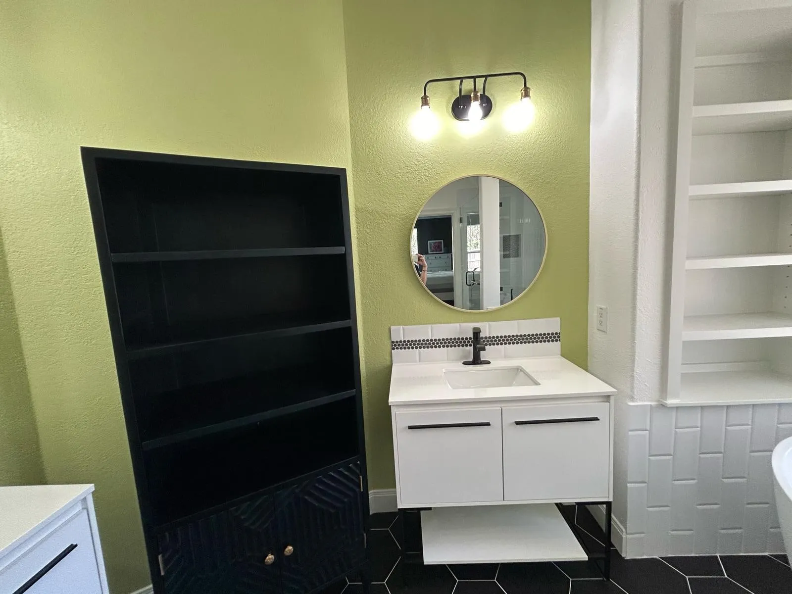 Bathroom remodel with a freestanding tub, black hexagon floor tile, and a floating vanity in The Woodlands, TX