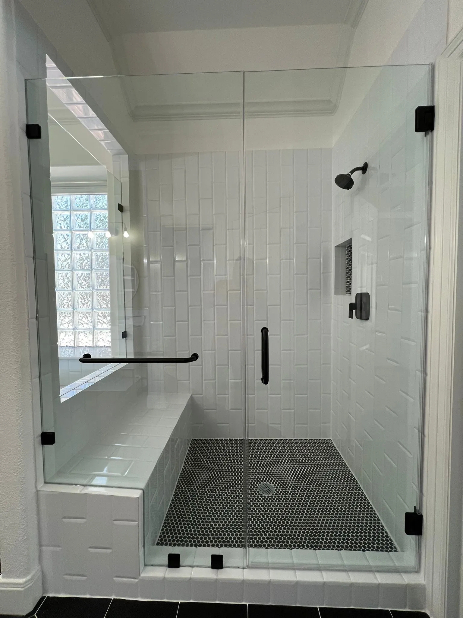 Bathroom remodel with a freestanding tub, black hexagon floor tile, and a floating vanity in The Woodlands, TX