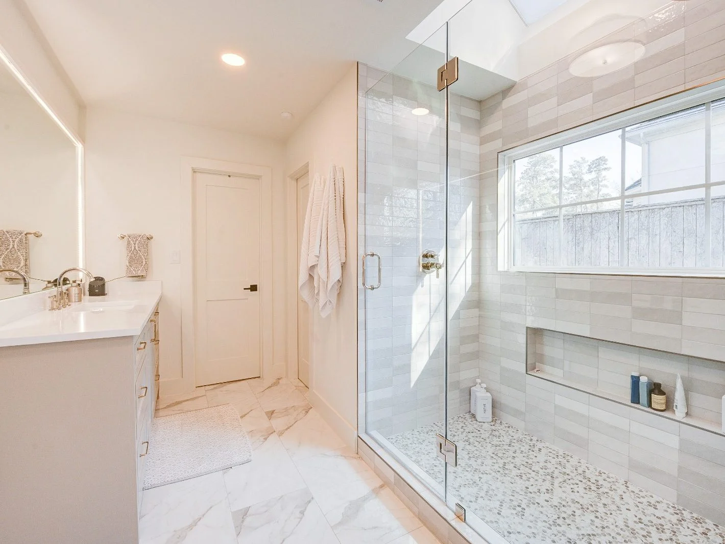 Low-threshold walk-in shower with marble flooring in The Woodlands, TX