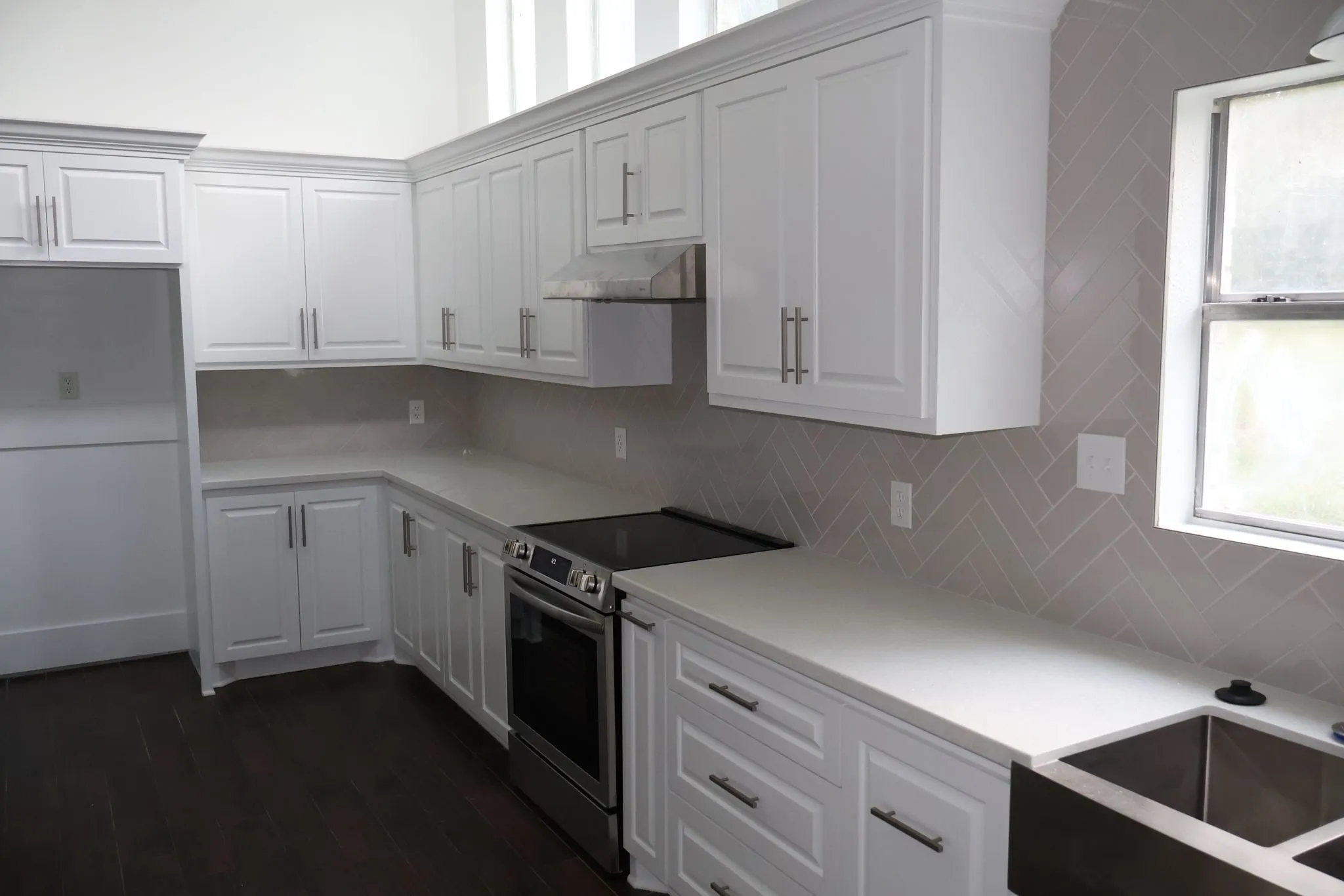White shaker kitchen remodel with a herringbone backsplash in Panther Creek, The Woodlands, TX