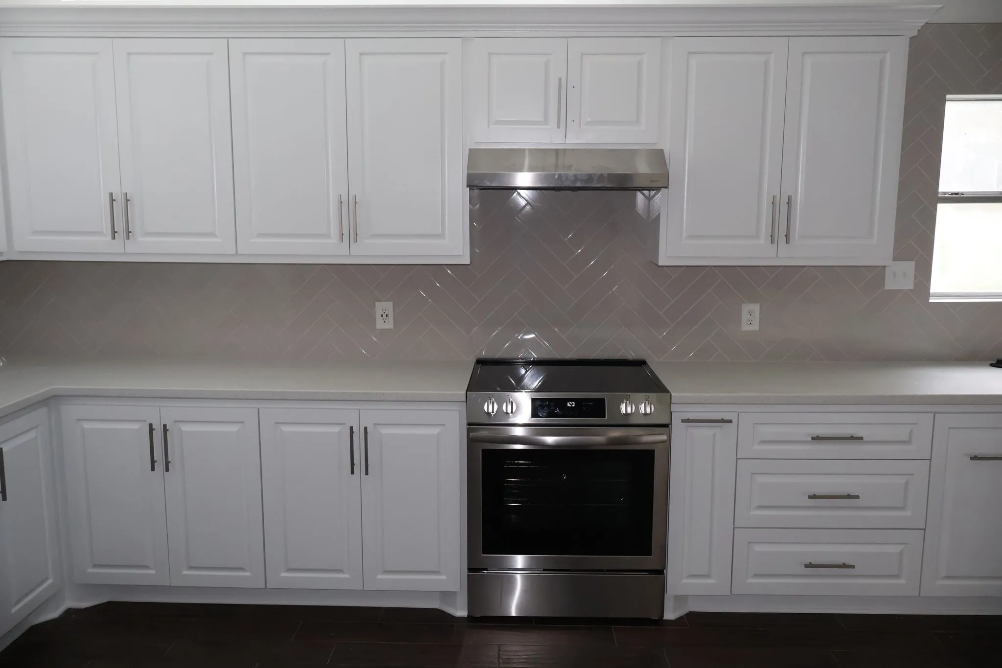 Herringbone tile backsplash set behind the range in a kitchen remodel in The Woodlands, TX