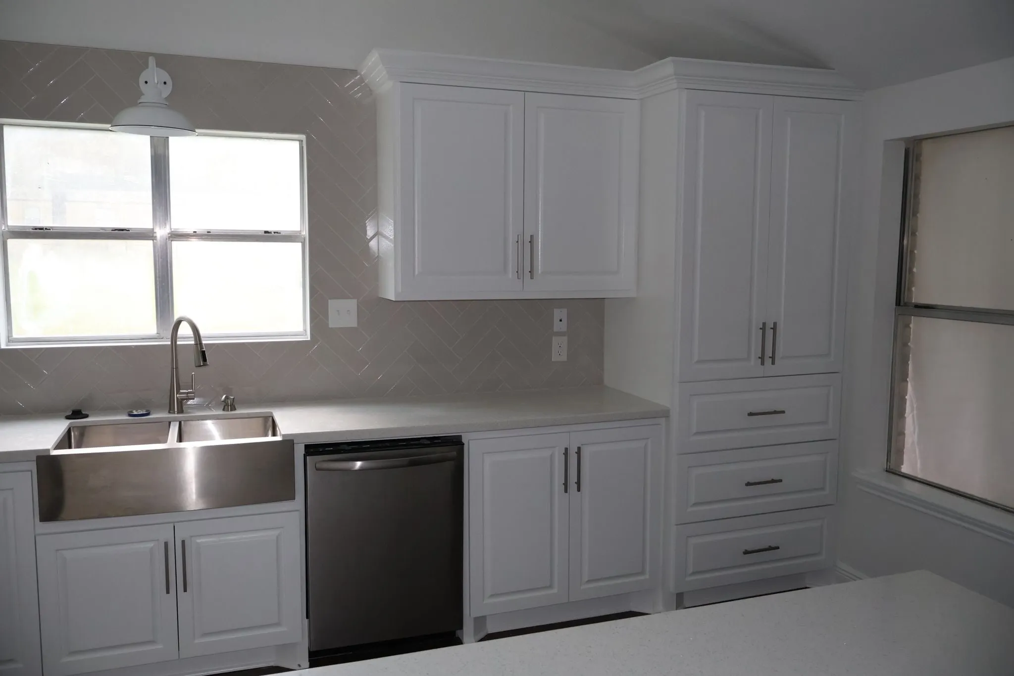 White shaker kitchen remodel with a herringbone backsplash in Panther Creek, The Woodlands, TX