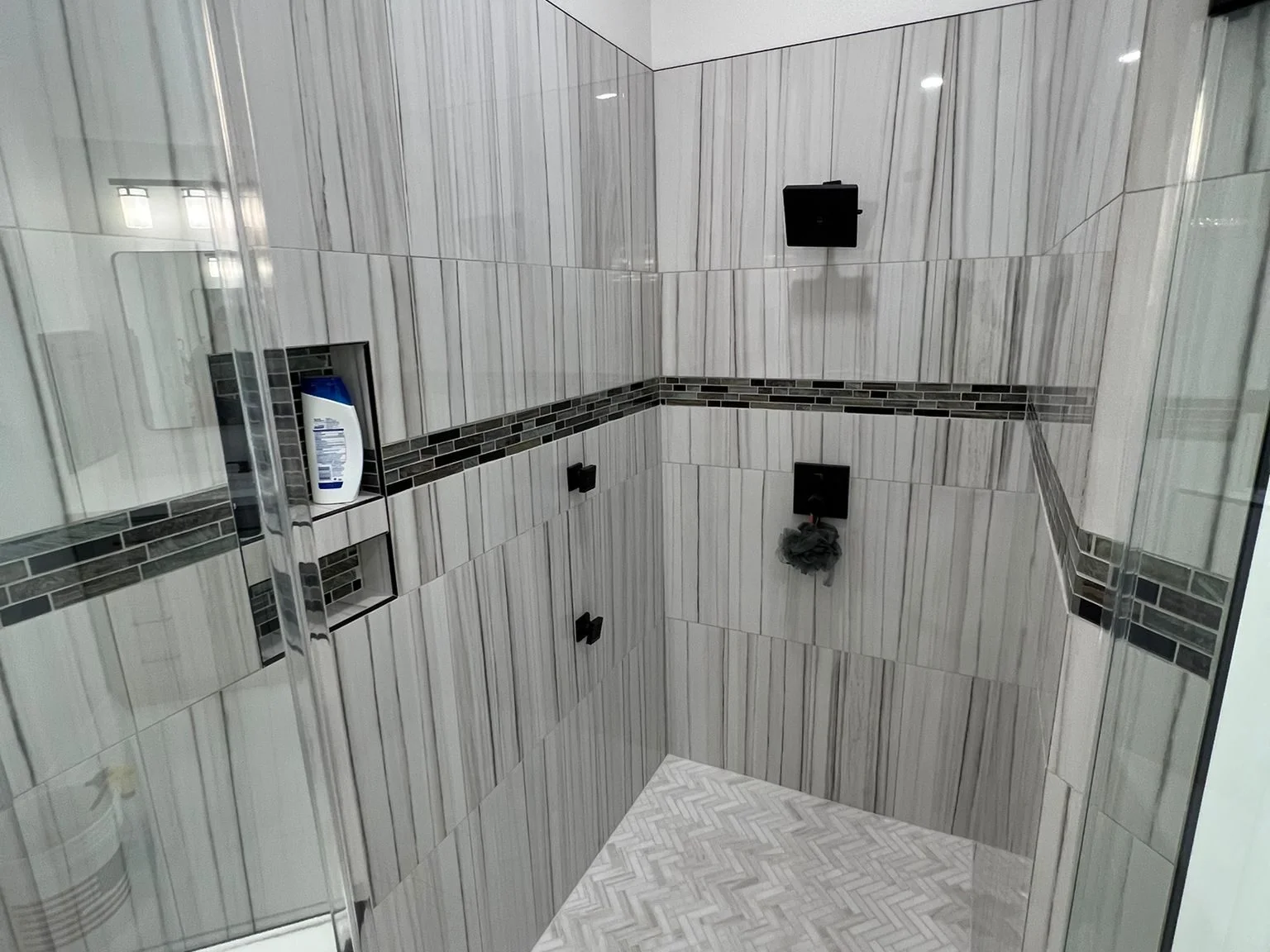 Large-format tile and stone setting in a walk-in shower in The Woodlands, TX