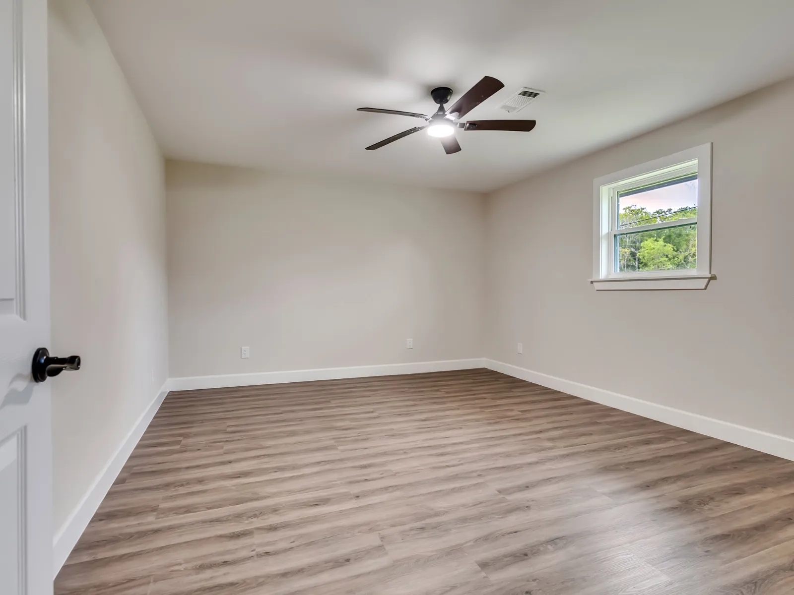 Refinished bedroom with new plank flooring and trim in a whole home renovation in The Woodlands, TX