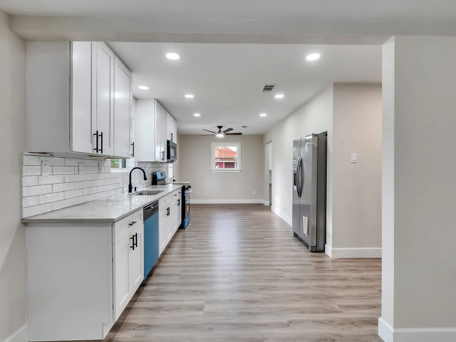 New kitchen with white shaker cabinetry and quartz counters in a whole home renovation in The Woodlands, TX